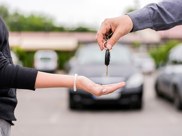 a man handing over car keys to a women